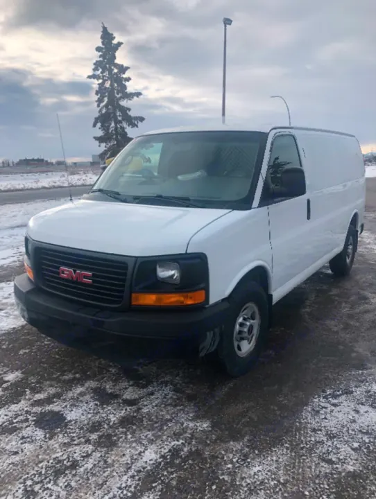 White GMC cargo van on snowy ground. Ideal for commercial transport or an RV rental project.. Gmc Savanna 2013