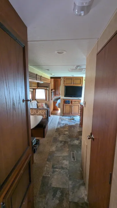 Spacious RV rental interior with a dinette, living area, TV, and bedroom beyond. Ready for adventure.. Jayco Jay Flight 2012