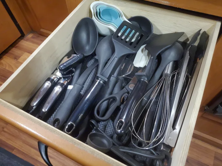 RV rental kitchen drawer filled with essential cooking utensils like spatulas, whisks, and measuring cups.. Thor Majestic 2014