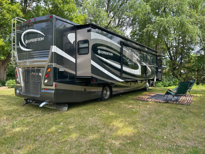 Large Expedition RV rental with slide-outs and awning, perfect for camping with chairs and rug.. Fleetwood Expedition 38B 2011