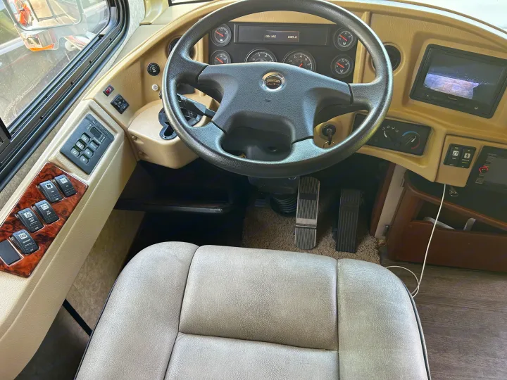 Inside an RV rental: detailed view of the driver's cockpit with steering wheel, Allison transmission controls, and gauges.. Fleetwood Expedition 38B 2011