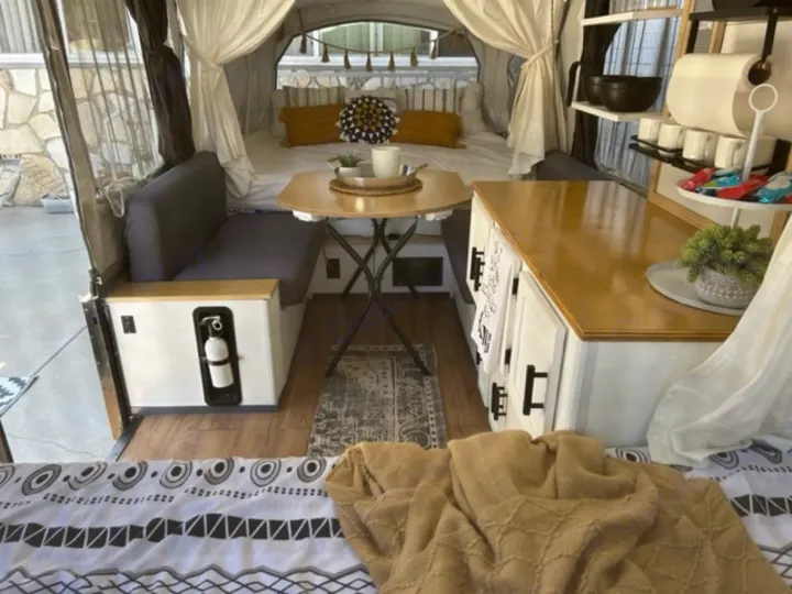 Cozy and functional RV rental interior, showcasing a renovated camper with dining, kitchenette, and comfortable bed.. Coleman Frontier 1993