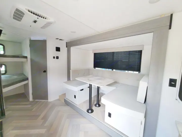 RV rental interior featuring a bright dinette with a marble-look table & accessible bunk beds.. Forest River Salem FSX 2023