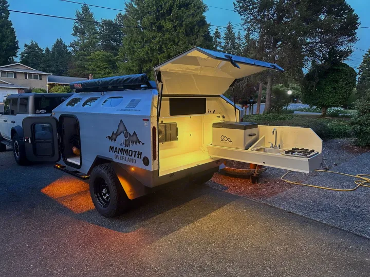 This Mammoth Overland trailer, a great RV rental option, features an illuminated outdoor kitchen setup. Ready for adventure!. Mammoth Overland Mammoth HV 2023