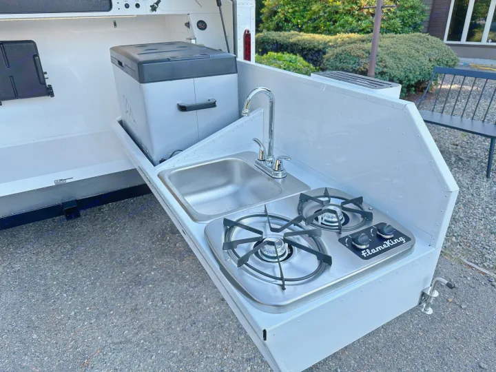 This RV rental includes an outdoor kitchen unit: a sink with faucet, 2-burner stove, and pull-out fridge, ideal for trips.. Mammoth Overland Mammoth HV 2023