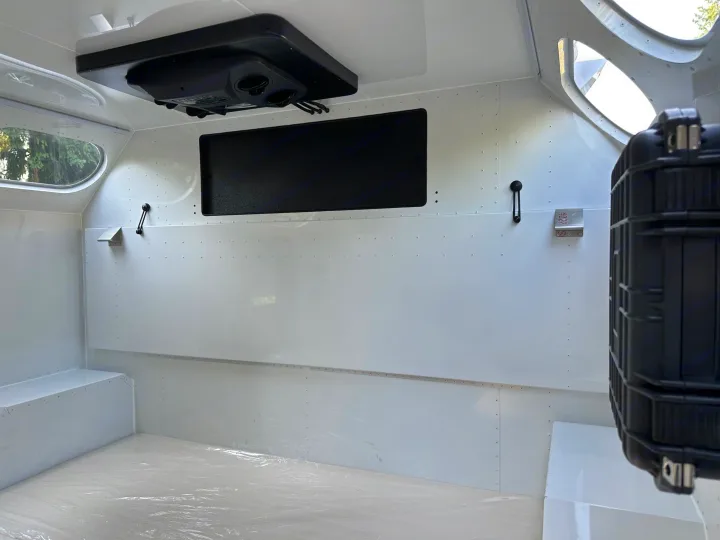 Spacious, white interior of an rv rental, featuring overhead AC, windows, & protective floor covering. Ideal for mobile travel.. Mammoth Overland Mammoth HV 2023