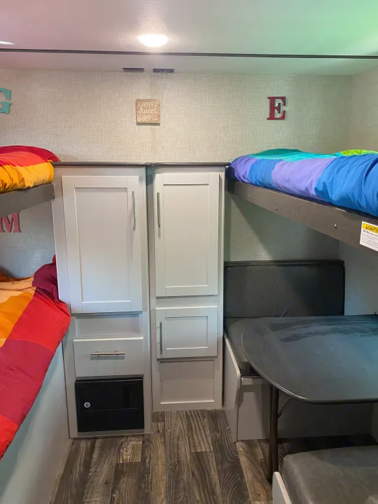 Inside this **RV rental**: colorful **bunk beds**, a cozy **dinette**, and functional **storage** space. Perfect for families.. Keystone RV Bullet Ultra Lite 2019
