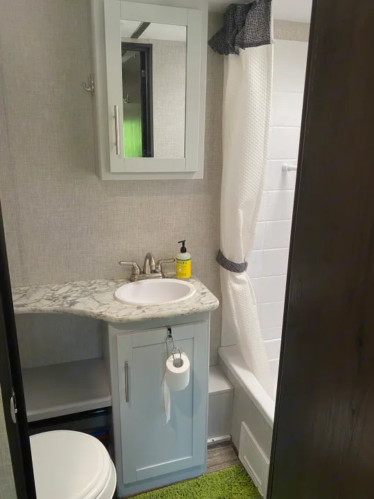 Compact RV rental bathroom features a vanity, sink, toilet, and shower. Clean and modern for your trip.. Keystone RV Bullet Ultra Lite 2019