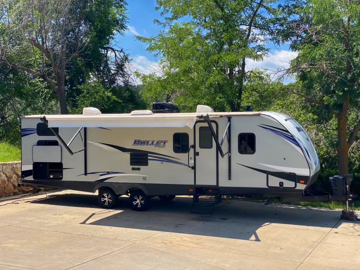 This white 'Bullet Ultra Lite' RV travel trailer with an extended awning and outdoor kitchen is ready for your next RV rental adventure.. Keystone RV Bullet Ultra Lite 2019
