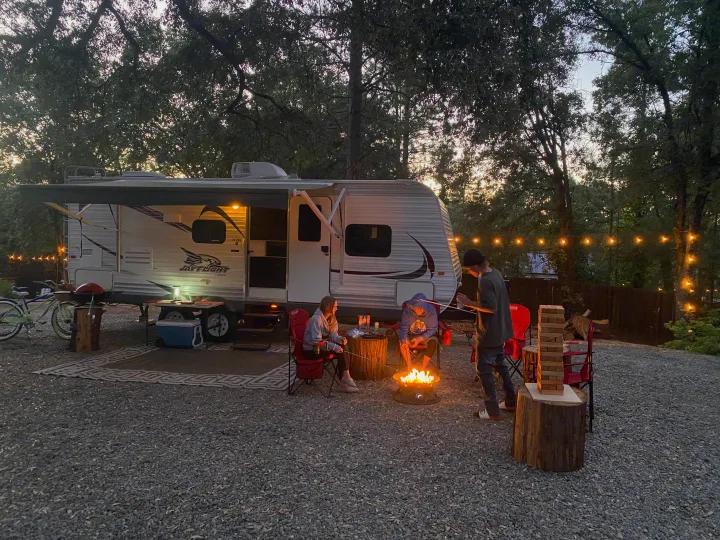 Fun with an RV rental: people around a campfire, playing Jenga at a lively outdoor campsite.. Jayco Jay Flight 2015