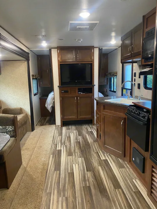 Spacious rv rental interior featuring a modern kitchen, entertainment area, and two cozy bedroom spaces.. Jayco Jay Flight SLX 2017