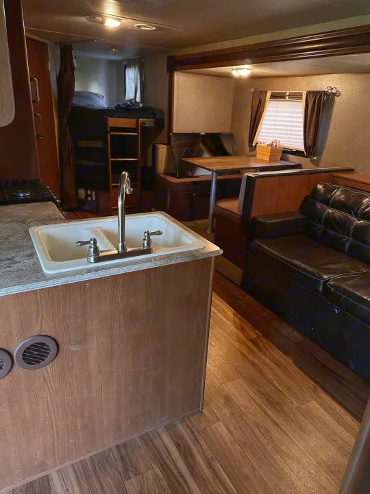 Spacious RV rental interior featuring kitchen, dining, living area, and bunk beds.. Forest River Wildwood X-Lite 2015