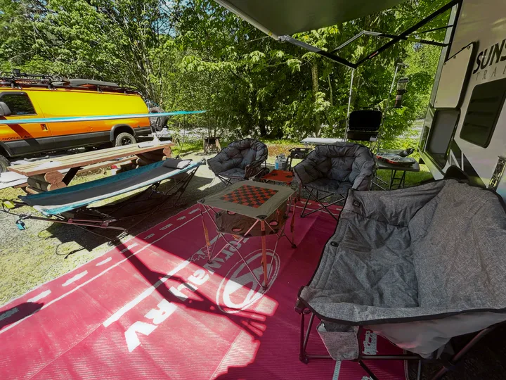 RV rental glamping setup! Enjoy comfy chairs, games, and nature at this spacious campsite with a travel trailer.. Sunset Trail 188BH 2022