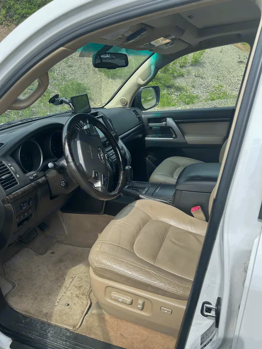 Full view of a Toyota Land Cruiser's tan leather interior, dashboard, and steering wheel. Explore this versatile rv rental option.. Toyota Land Cruiser 2008
