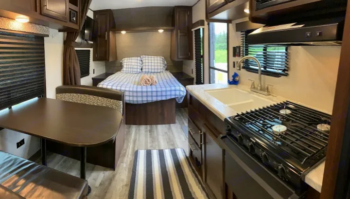 Spacious RV rental interior featuring a cozy bed, full kitchen, and dinette. Perfect for your next adventure!. Jayco Jay Flight SLX 2019