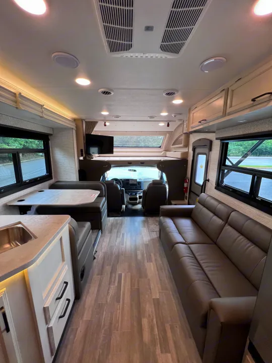 Step inside this modern and spacious RV rental, featuring a full living area with dinette, sofa, and kitchen.. Jayco Redhawk 31F 2024