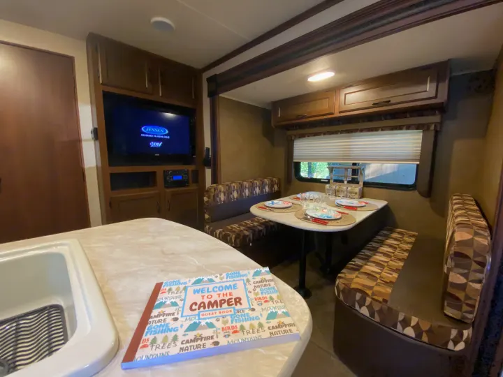 Experience the comfort of an RV rental: fully equipped dinette, kitchen, and TV setup for your next adventure.. Jayco Jay Flight 2015