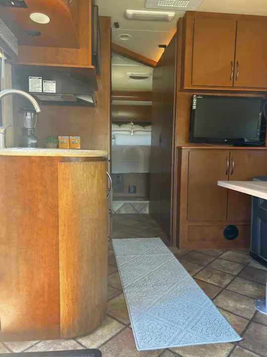 RV rental interior featuring a full kitchen, living area, and a hallway leading to the bedroom.. Thor Citation 2015