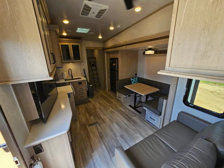 Spacious RV rental interior with a modern kitchen, comfy dinette, and living area, featuring light cabinets and wood-look floors.. Forest River Flagstaff Super Lite 2022