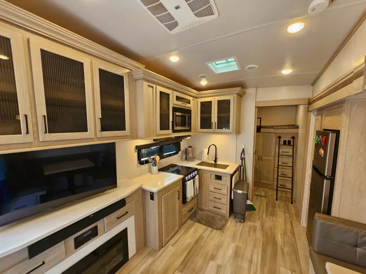 This modern RV rental features a bright interior with a compact kitchen (stove, sink, fridge) and living area (TV, fireplace).. Forest River Flagstaff Super Lite 2022