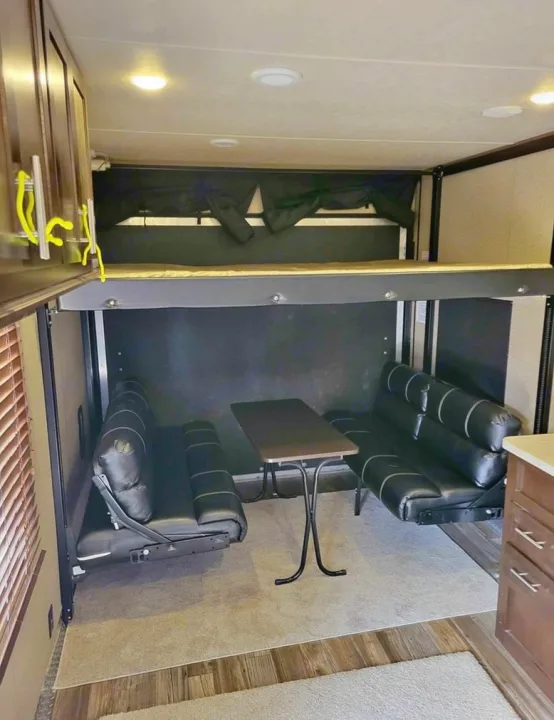 RV rental interior: A spacious living area featuring a raised bunk bed, two facing sofas, and a table.. Forest River Wolf Pack 2016