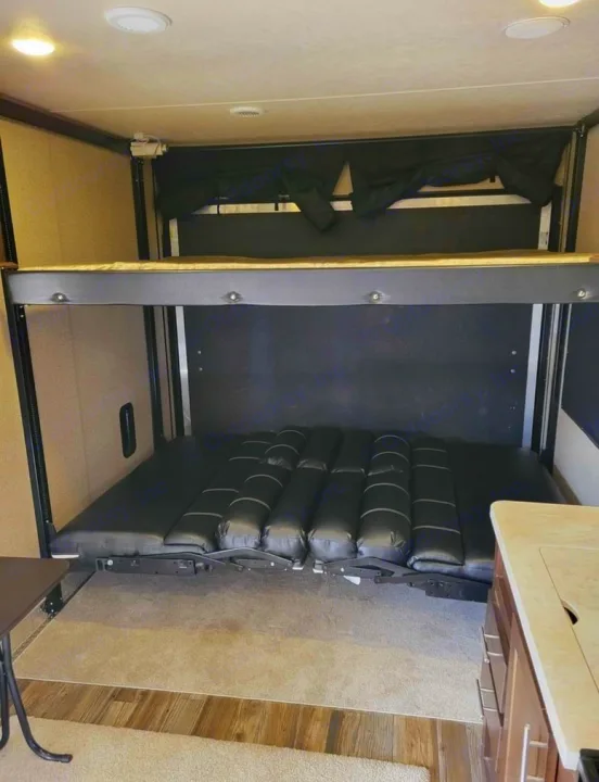 RV rental: Inside a toy hauler, featuring a comfortable bunk bed system with a convertible lower bed.. Forest River Wolf Pack 2016