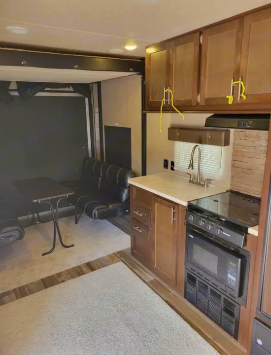 Spacious RV rental interior with a fully equipped kitchen and comfortable living/garage area, perfect for adventurers.. Forest River Wolf Pack 2016