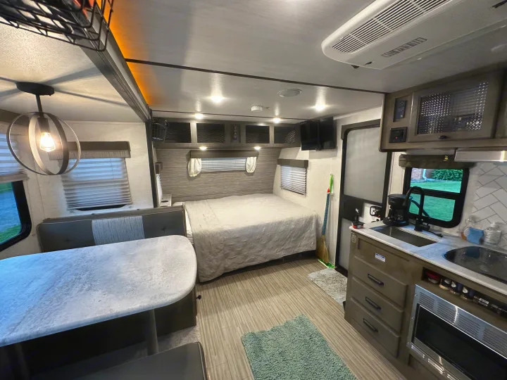 Spacious RV rental interior featuring a cozy bedroom, dinette, and functional kitchen with modern amenities.. Forest River Surveyor Legend 2021