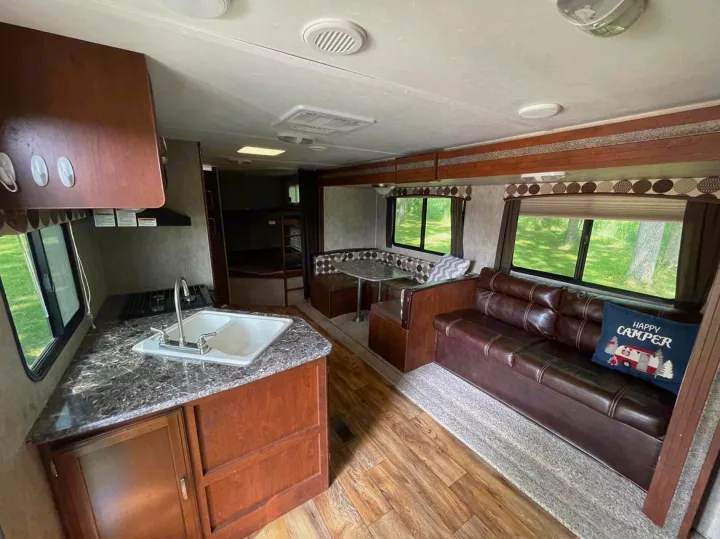 Spacious RV rental interior featuring a full kitchen, comfortable dinette, sofa, and bunk beds. Ready for your adventure.. Keystone RV Passport Ultra Lite 2015