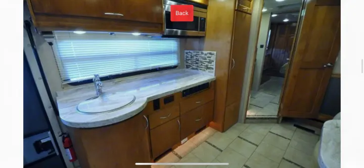 RV rental interior: well-appointed kitchen with sink, microwave, ample storage, and tiled flooring. Perfect for travel adventures.. Monaco Vesta 2012