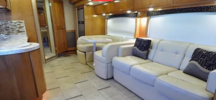 Bright RV rental interior with a fully equipped kitchen, spacious dining booth, and a comfortable sofa in the living area.. Monaco Vesta 2012