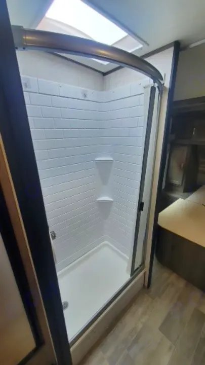 Bright, clean shower with a skylight & shelves inside a compact rv rental, perfect for your next trip.. Gulf Stream Vista Cruiser 2021