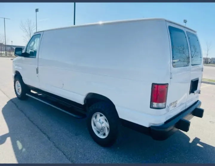 White Ford E-Series van with running boards, a versatile base for rv rental or conversion.. Ford Econoline 2012