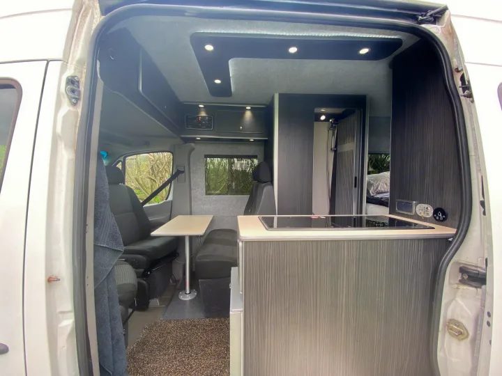 RV rental interior from the rear doors, showing a kitchen, shower, dining table, and bed.. Mercedes-Benz Sprinter 2012