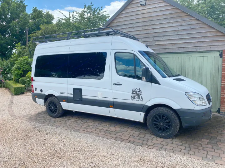 White Mercedes motorhome from Moira Motor Home Hire, an RV rental van, parked on a paved driveway.. Mercedes-Benz Sprinter 2012