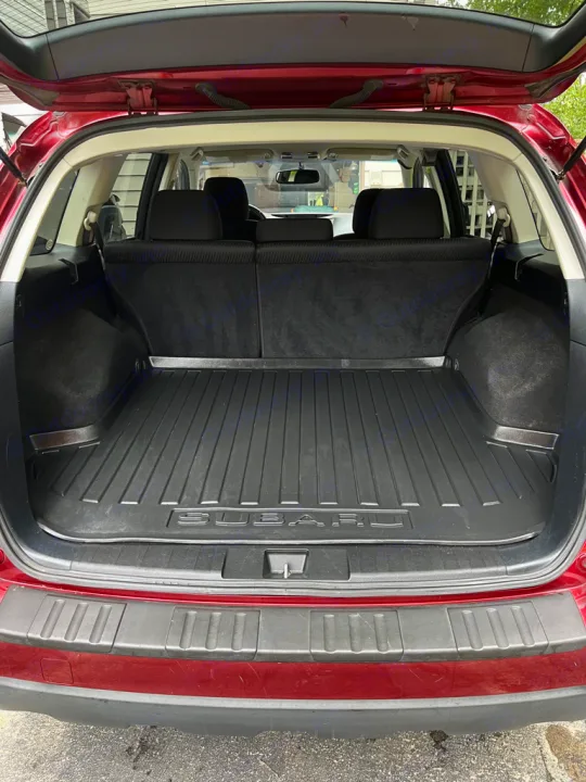 Red Subaru Outback's open cargo area with protective mat, ideal for any trip or **RV rental** prep.. Subaru Outback 2012