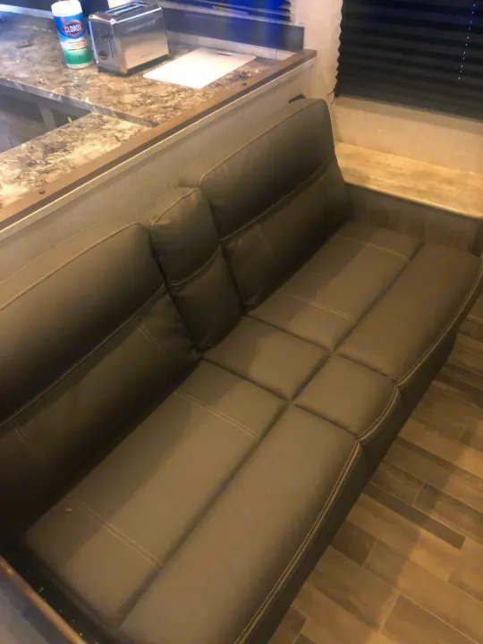 Compact RV rental with comfy grey sofa, integrated kitchen counter, toaster, and wipes. Ready for your adventure.. Crossroads RV Zinger Lite 2022