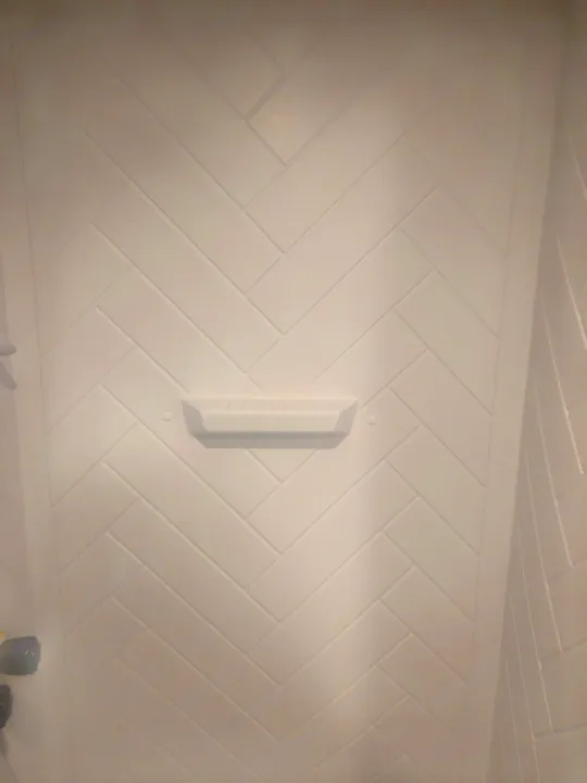 Clean white herringbone tile shower with built-in shelf in this RV rental.. Crossroads RV Zinger Lite 2022