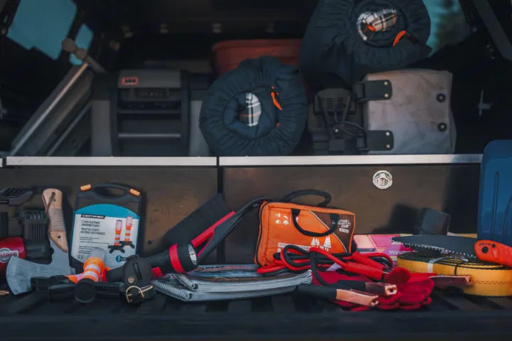 Camping & emergency gear, like ARB fridge & jumper cables, neatly organized in an RV rental for your next adventure.. Toyota Tacoma 2023