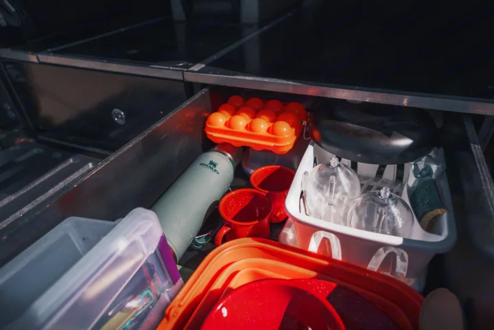 RV rental kitchen drawer: organized with camping cookware, Stanley thermos, and essential camp gear.. Toyota Tacoma 2023