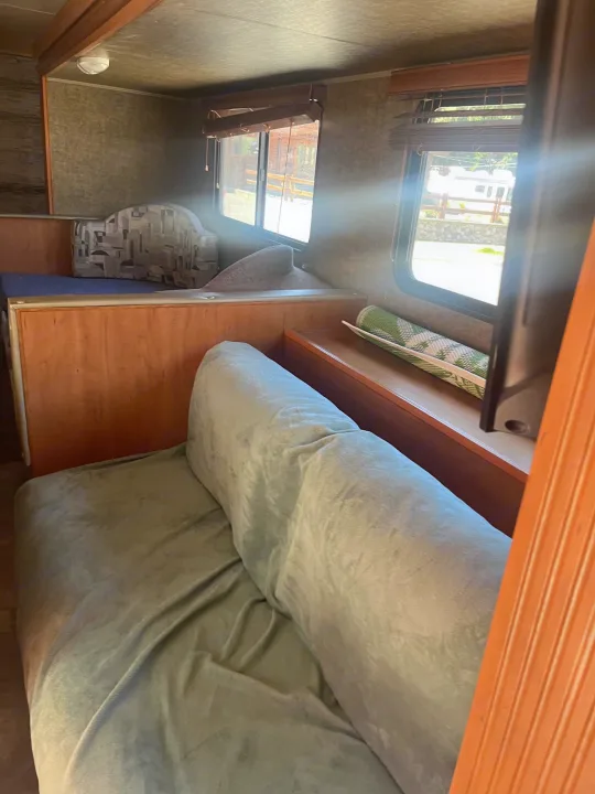RV rental: Bright interior with a comfortable sofa, windows showing an outdoor scene.. Forest River Cherokee Grey Wolf 2015