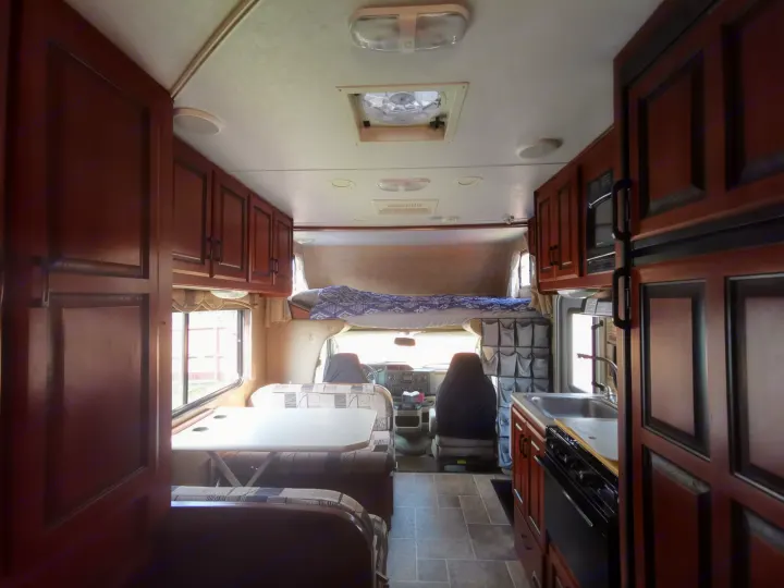 Spacious RV rental interior with kitchen, dinette, and overhead bed, perfect for your next road trip.. Forest River Sunseeker 2010