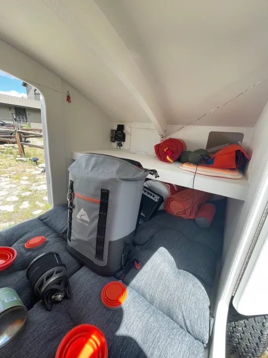 Compact RV rental interior: Sleeping area, Ozark Trail cooler, JetBoil stove, and camping gear for travel adventures.. Other Other 2022