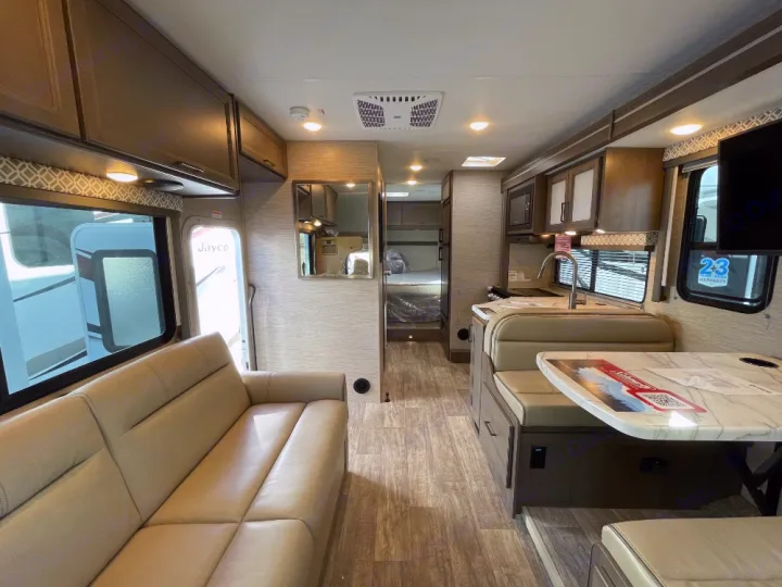 Explore this RV rental's spacious interior: comfy couch, modern kitchen, dinette, & bunks. Ready for adventure!. Thor Coleman 2023