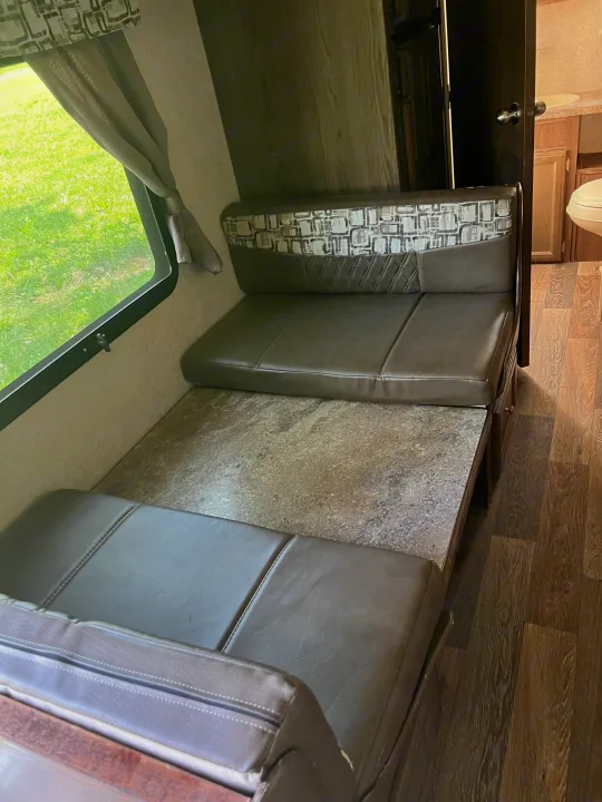 Cozy RV rental dinette with comfortable seating, a table, and a view of nature. Perfect for meals on your road trip!. Forest River Rockwood Mini Lite 2017