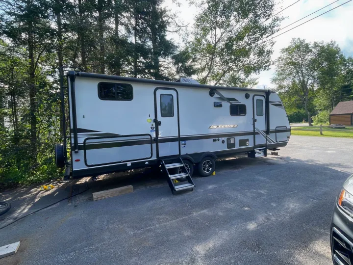 Spacious Jay Feather RV rental parked on an asphalt lot at a sunny campground, ready for outdoor adventures.. Jayco Jay Feather 2021