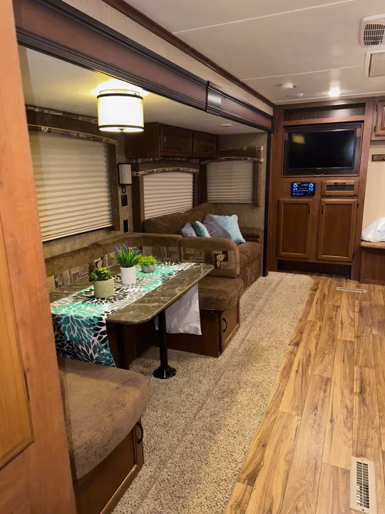 An RV rental's inviting interior, featuring a dinette with bench seating, a cozy sofa, and built-in entertainment.. Jayco Jay Flight 2016