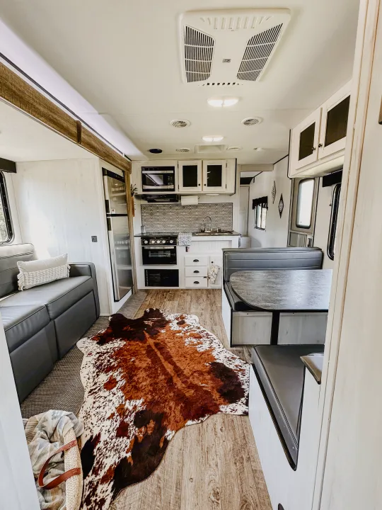 This bright, modern RV rental interior features a full kitchen, comfortable dining booth, and cozy living area.. Heartland RVs Trail Runner 2022