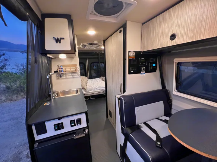 RV rental: well-equipped interior with kitchen, dining area, comfy bed, and beautiful outdoor views. Ready for adventure.. Winnebago Revel 2023