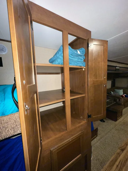 Inside an RV rental: a neat wooden cabinet with towels, perfect for storage in a cozy living and sleeping area.. Jayco Jay Flight 2016
